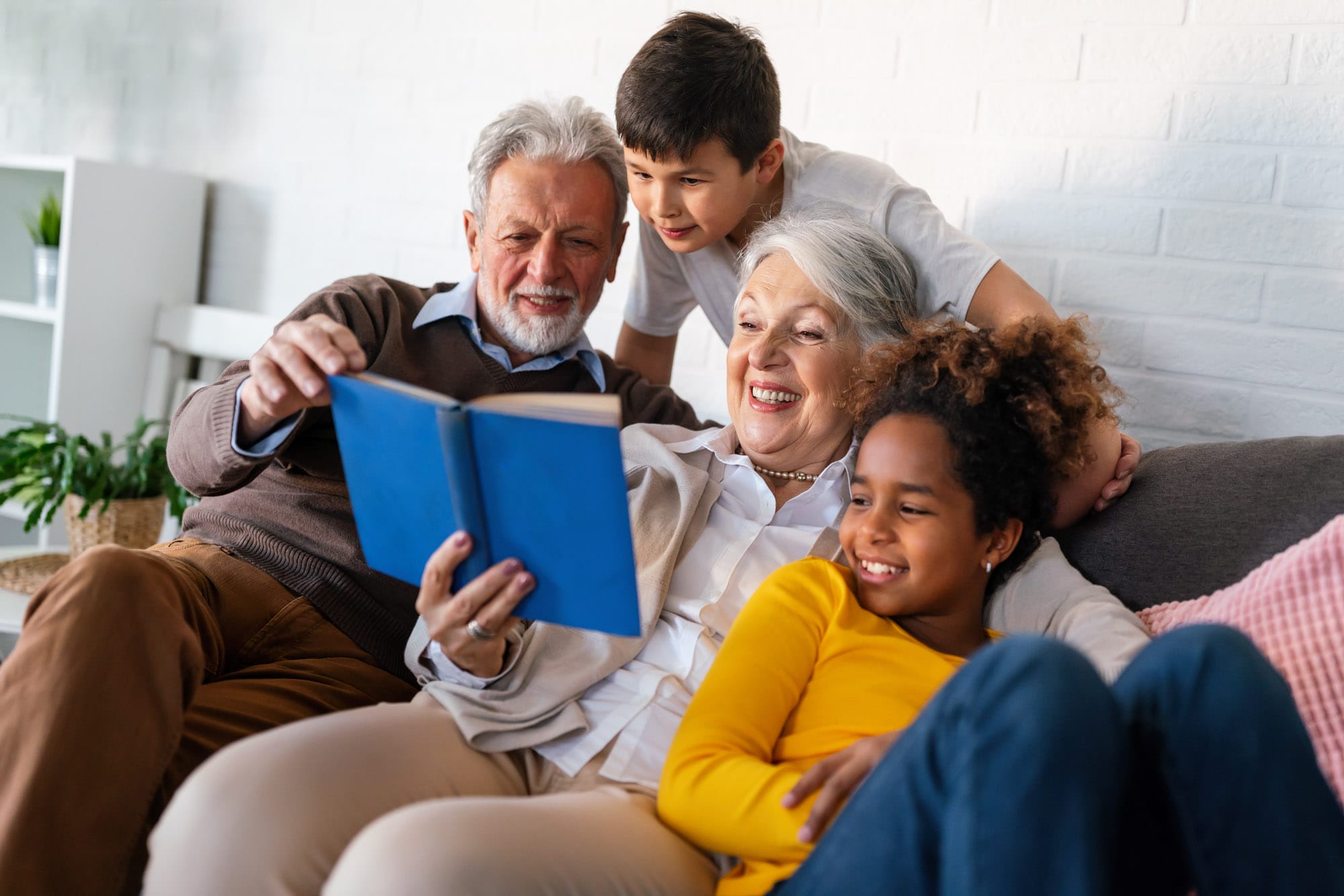 Happy family reading book together on couch.