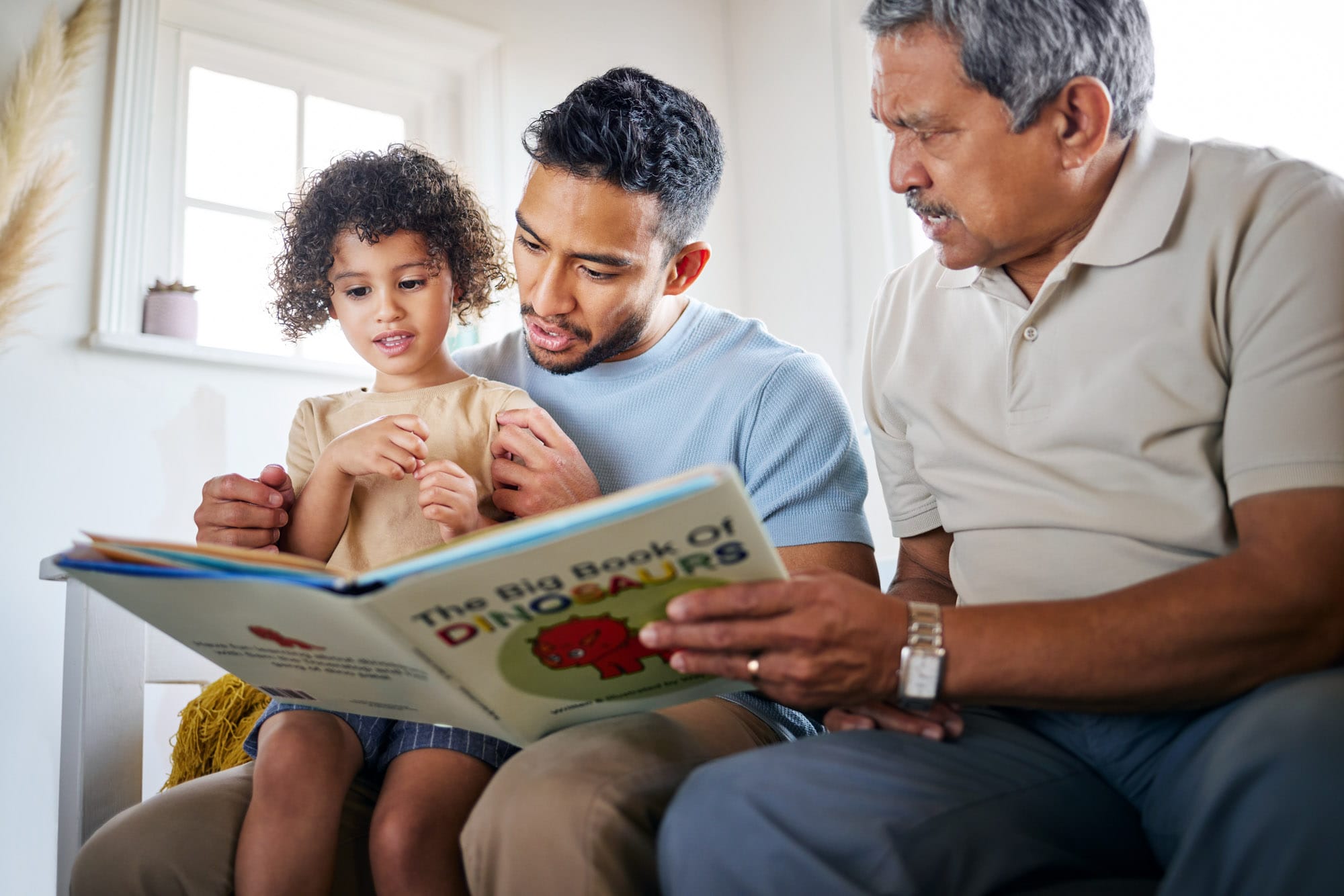 Family reading a dinosaur book together.