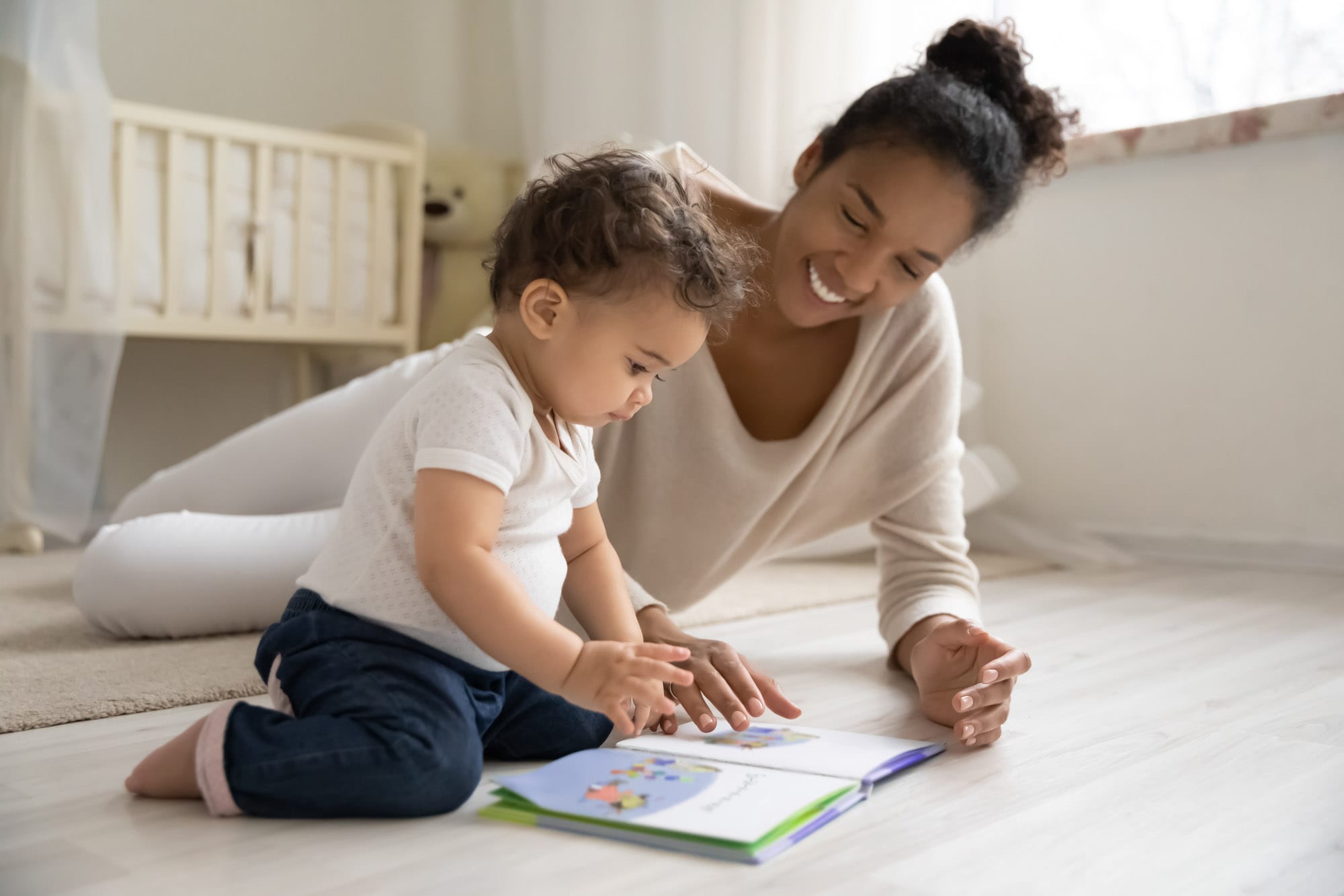 Smiling woman and child reading a book together.